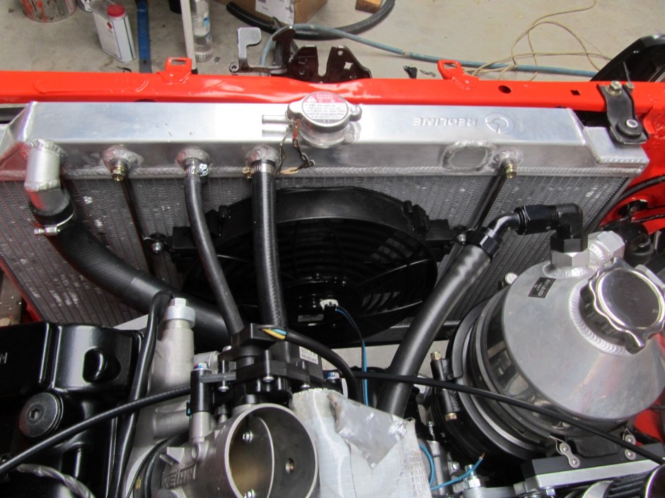 The radiator modified with additional hoses and fan mounted.